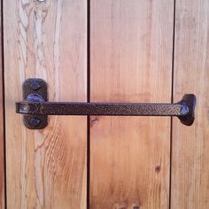 a close up of a metal handle on a wooden door