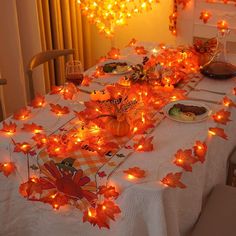 the table is covered with fall leaves and lights