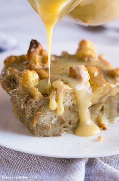 a piece of bread pudding is being drizzled with caramel sauce