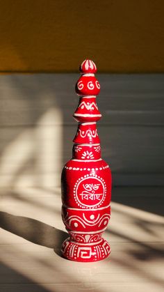 a red vase sitting on top of a white floor