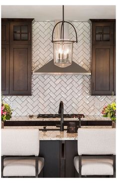 a kitchen with a stove top oven sitting under a hanging light over the countertop