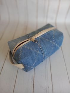 a denim pouch with zipper is sitting on a white table