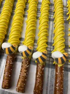 four yellow and black striped candles with bees on them