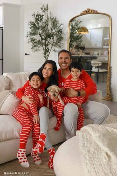 a man and two children are sitting on a couch with their dog in matching pajamas