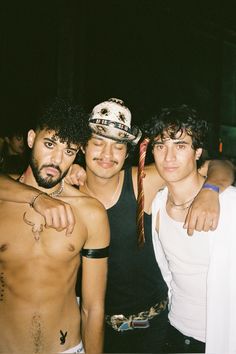 three men standing next to each other at a party