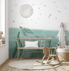 a baby's room with a turtle and stars painted on the wall behind it