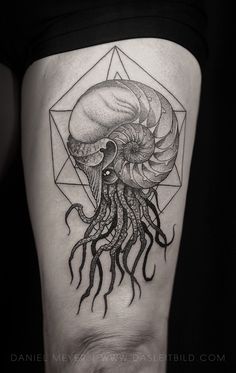 a black and white tattoo with an octopus on the thigh