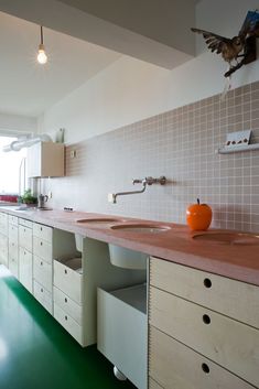 a kitchen with green flooring and two sinks on the counter top next to each other