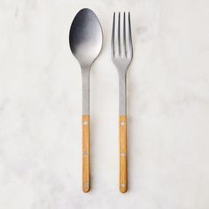 two forks and one spoon on a marble surface with white dots in the middle,