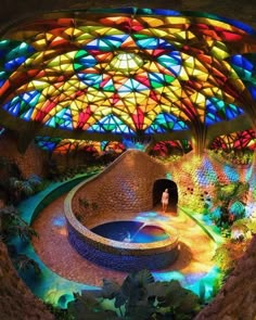 the inside of a building with colorful stained glass windows and a fountain in the center