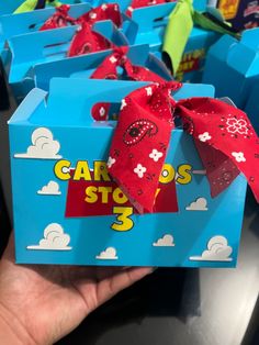 someone is holding up a blue box with a red bow on it that says carros step 3