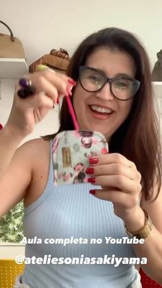 a woman holding up a cell phone in front of her face and wearing eyeglasses