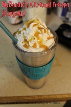 an ice cream sundae with caramel and whipped cream in a plastic cup on a table