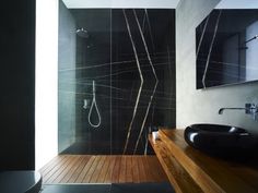 a bathroom with a wooden floor and black walls