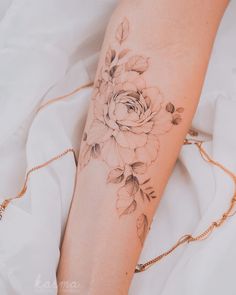 a woman's arm with a rose tattoo on it