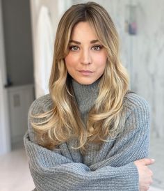 a woman with blonde hair is posing for the camera