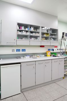 an empty laboratory with lots of white cabinets and counter top space for medical supplies on the floor