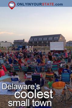 people are sitting in lawn chairs on the beach and watching an outdoor movie at dusk