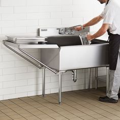 a man is washing his hands in the sink while standing next to a wall mounted faucet