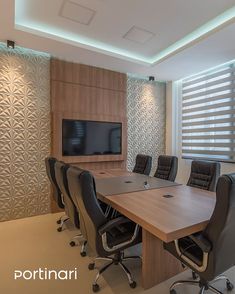 an empty conference room with black chairs and a flat screen tv mounted on the wall