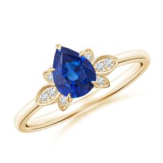 a yellow gold ring with an oval blue sapphire and diamonds