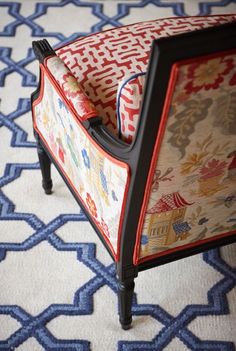 an upholstered chair with red and blue fabric