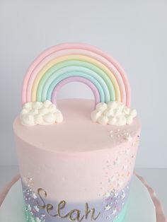 there is a pink cake with a rainbow on it