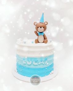 a teddy bear sitting on top of a cake