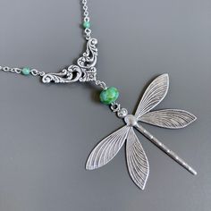 "Large Silver Dragonfly Necklace -  Large Antiqued Silver plated Dragonfly dangles from a Turquoise Czech Glass  Bead and Antiqued Silver Floral Connector with 2 small Czech Turquoise Glass Beads. The dragonfly is 2\" high x 2.5\" wide (63mm x 50mm) and has a hollow back. Chain Length is approximately 28.5\".  The Dragonfly hangs down an additional 4\" from the chain. Stainless Steel Chain For other dragonfly jewelry:  https://www.etsy.com/shop/mcstoneworks/search?search_query=dragonfly&order=da Green Adjustable Jewelry With Butterfly Charm, Green Bohemian Butterfly Jewelry, Bohemian Green Butterfly Jewelry, Handmade Green Dragonfly Jewelry, Elegant Green Dragonfly Shaped Jewelry, Green Dragonfly Jewelry For Gifts, Green Dragonfly Jewelry As A Gift, Green Dragonfly Jewelry Gift, Silver Dragonfly Necklace