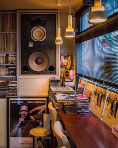 a room filled with lots of different types of records and cds on top of a wooden table