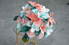 a bouquet of pink and blue flowers sitting on top of a metal stand