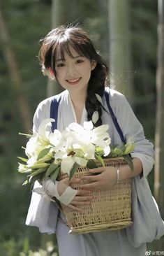 a woman holding a basket with flowers in it