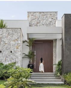 a woman is standing in front of a door with steps leading up to the entrance