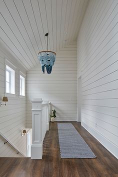 an empty room with white walls and wood flooring is seen in this image from the hallway