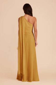 the back of a woman wearing an asymmetrical dress with one shoulder draped over it