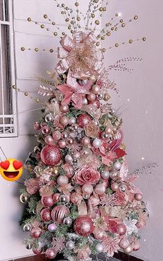 a pink christmas tree decorated with ornaments