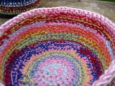 two crocheted baskets sitting on top of a wooden table