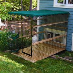 a house with a green awning on the side of it and a cat inside