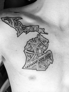 a black and white photo of a man's chest with a map tattoo on it