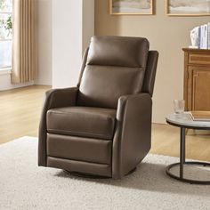 a brown recliner chair sitting on top of a white rug next to a table