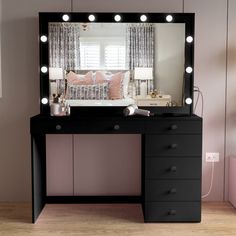 a black vanity with lights on it in front of a mirror and pink bedding