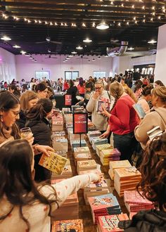 many people are looking at books on tables