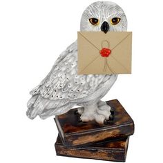 an owl statue with a letter in its mouth