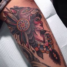 a person with a tattoo on their arm and headdress in the shape of a wolf