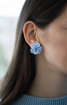 a close up of a person wearing some kind of earring with flowers on it