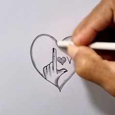 someone is drawing a heart with a pencil