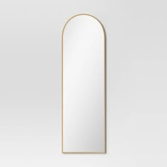 an arched mirror on a white wall