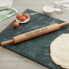 rolling in the dough on top of a green cutting board next to eggs and flour