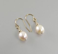 These earrings are made with lovely white teardrop cultured freshwater pearls, 14k gold beads and bead caps, and 14k gold filled earring hooks. The earrings are approximately three fourths of an inch (1.905cm) in length, not including the earring hook. The earrings are available with 14k gold filled lever back earring hooks or 14k gold filled French wire earring hooks. Please choose the style of earring hook you want from the drop-down menu. The earrings will arrive in an attractive box suitable Gold Teardrop Pearl Earrings With French Hook, Teardrop Pearl Drop Earrings In 14k Gold Filled, Teardrop Pearl Earrings With French Hook, White Teardrop Pearl Earrings With French Hook, Teardrop Pearl Earrings, French Wire Earrings, Gold Filled Earrings, French Wire, Earrings White