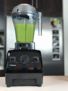 a blender filled with green liquid on top of a counter